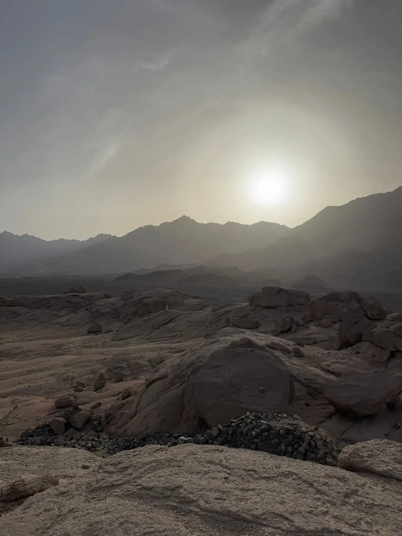 Die Sonne steht tief über den Bergketten der südlichen Sahara